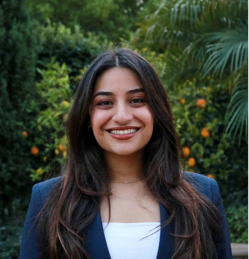 Dr. Jasaman Tojjar — physician-scientist in navy blazer, smiling warmly in a garden setting
